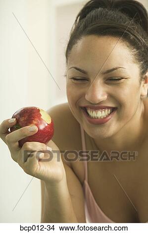 Young woman holding a red apple. View Large Photo Image Picture - Young woman holding a red apple. . Fotosearch