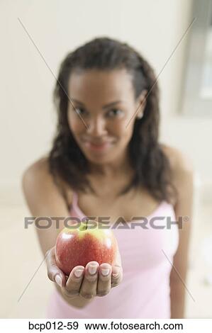 Young woman holding an apple. View Large Photo Image Stock Photo - Young woman holding an apple.. Fotosearch