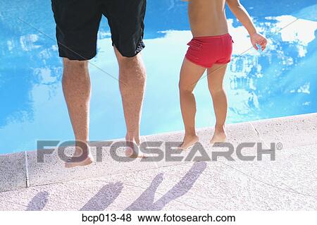 Stock Photo - A father and child jumping into a pool.. Fotosearch