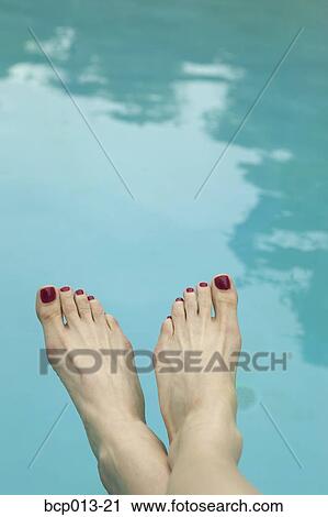 Stock Image - A woman's bare feet by the pool. . Fotosearch