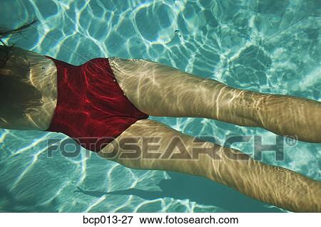 Stock Photo - High angle view of a woman swimming underwater.. Fotosearch