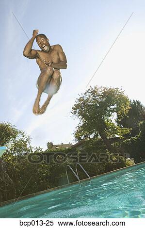 Man leaping into a swimming pool. View Large Photo Image Stock Photography - Man leaping into a swimming pool.. Fotosearch