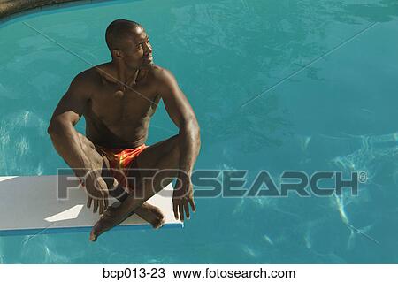 Man sitting on a diving board. View Large Photo Image Stock Image - Man sitting on a diving board. . Fotosearch