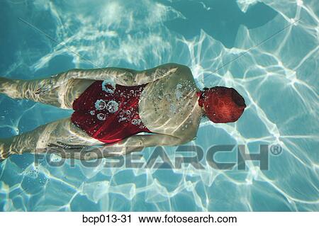 Overhead view of a woman swimming underwater. View Large Photo Image Stock Image - Overhead view of a woman swimming underwater.. Fotosearch
