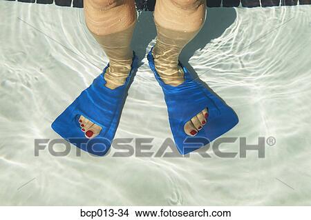 Picture - Overhead view of feet in swim fins.. Fotosearch
