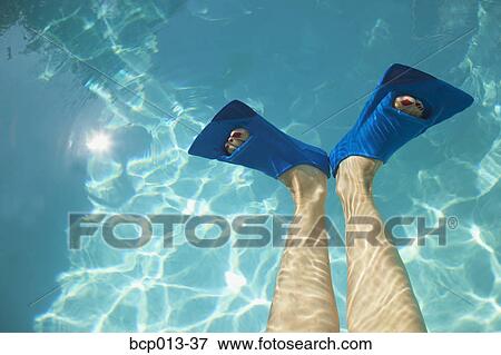 Stock Photo - Overhead view of feet in swim fins.. Fotosearch