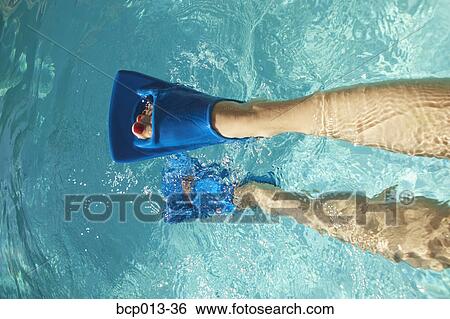 Stock Photograph - Overhead view of feet in swim fins.. Fotosearch