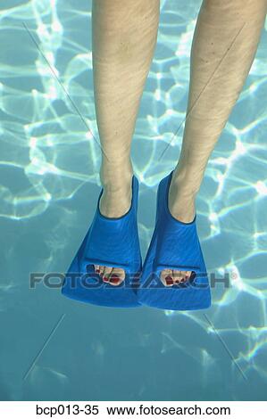 Stock Photography - Overhead view of feet in swim fins.. Fotosearch