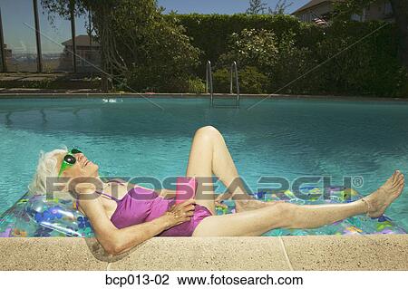 Senior lying on a raft in a pool. View Large Photo Image Stock Image - Senior lying on a raft in a pool.. Fotosearch