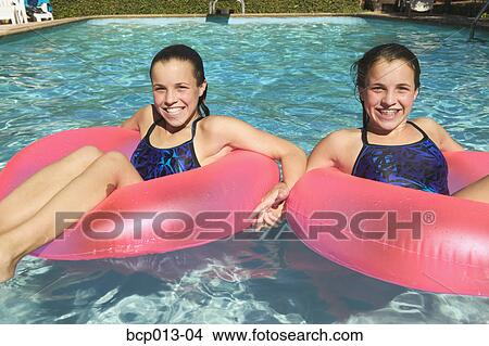Twin teen girls in a pool. View Large Photo Image Picture - Twin teen girls in a pool.. Fotosearch