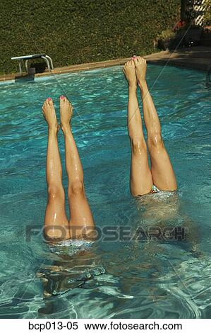 Two pairs of girls' legs pointing up out of a swimming pool. View Large Photo Image Stock Photography - Two pairs of girls' legs pointing up out of a swimming pool.. Fotosearch