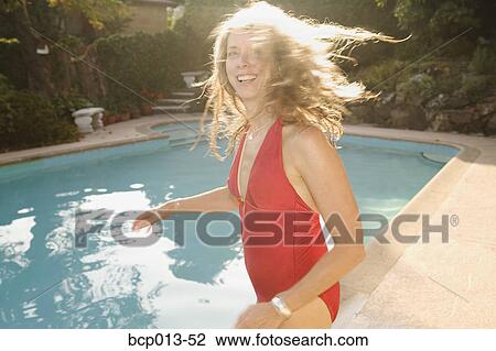 Stock Image - Woman tossing her hair at poolside.. Fotosearch