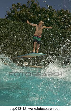 Young boy preparing to dive into a pool. View Large Photo Image Stock Image - Young boy preparing to dive into a pool.. Fotosearch