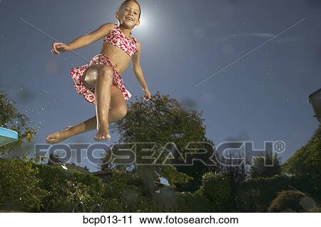 Young girl jumping into a pool. View Large Photo Image Stock Image - Young girl jumping into a pool.. Fotosearch