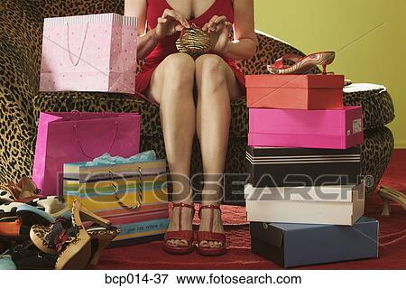 A seated woman surrounded by shopping bags and boxes. View Large Photo Image Stock Photo - A seated woman surrounded by shopping bags and boxes. . Fotosearch