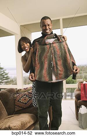 A woman helping her husband model a new jacket. View Large Photo Image Stock Image - A woman helping her husband model a new jacket.. Fotosearch