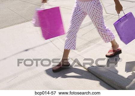 A woman in polka dot pants carrying shopping bags. View Large Photo Image Stock Photo - A woman in polka dot pants carrying shopping bags.. Fotosearch