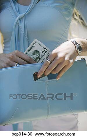 Close-up of a woman pulling cash from her purse. View Large Photo Image Stock Image - Close-up of a woman pulling cash from her purse. . Fotosearch