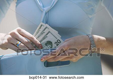 Close-up of a woman pulling cash from her purse. View Large Photo Image Stock Image - Close-up of a woman pulling cash from her purse. . Fotosearch