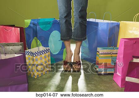 Cropped image of a woman standing among shopping bags. View Large Photo Image Stock Photo - Cropped image of a woman standing among shopping bags.. Fotosearch