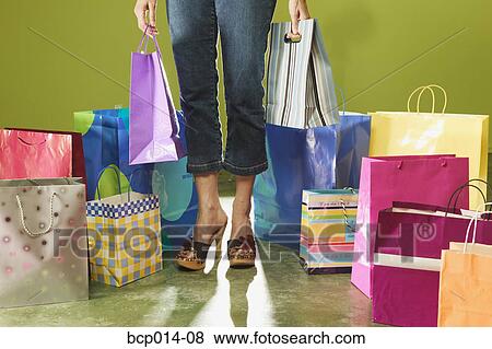 Cropped image of a woman standing among shopping bags. View Large Photo Image Stock Photo - Cropped image of a woman standing among shopping bags.. Fotosearch