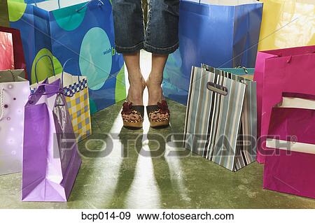 Cropped image of a woman standing among shopping bags. View Large Photo Image Stock Photo - Cropped image of a woman standing among shopping bags.. Fotosearch
