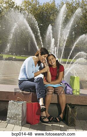 Seated mother and daughter talking on the phone. View Large Photo Image Stock Photo - Seated mother and daughter talking on the phone.. Fotosearch