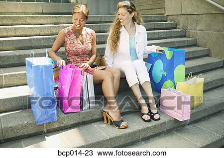 Two young women showing each other their purchases. View Large Photo Image Stock Image - Two young women showing each other their purchases.. Fotosearch