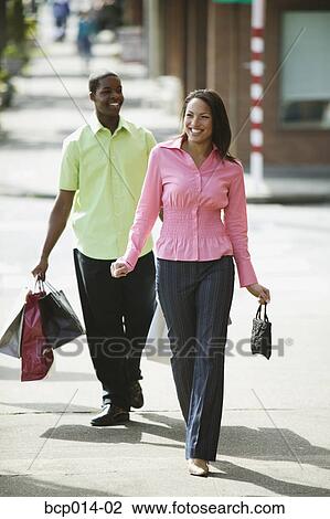 Young couple strolling and carrying shopping bags. View Large Photo Image Stock Image - Young couple strolling and carrying shopping bags. . Fotosearch