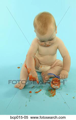 A baby boy getting messy while eating. View Large Photo Image Stock Photography - A baby boy getting messy while eating.. Fotosearch