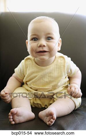 A baby boy sitting in a chair. View Large Photo Image Picture - A baby boy sitting in a chair.. Fotosearch