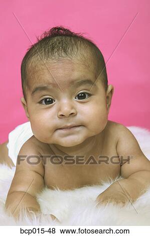 A baby girl lounging on a white rug. View Large Photo Image Stock Photo - A baby girl lounging on a white rug.. Fotosearch