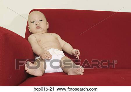 A baby seated on a red sofa and wearing a diaper. View Large Photo Image Stock Image - A baby seated on a red sofa and wearing a diaper. . Fotosearch