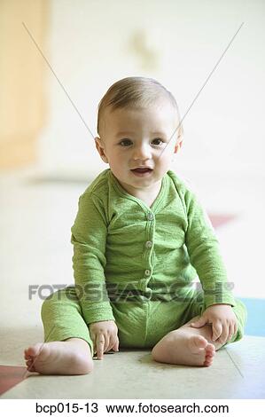 A baby sitting on a kitchen floor. View Large Photo Image Stock Image - A baby sitting on a kitchen floor.. Fotosearch