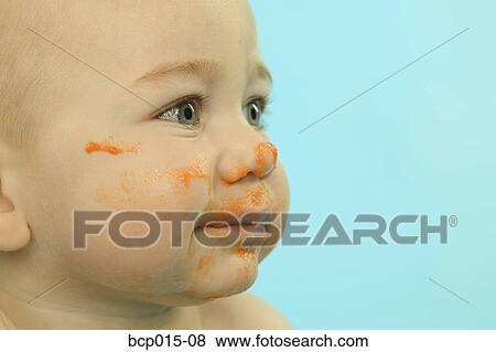 Stock Photo - A baby with his face smeared with baby food.. Fotosearch