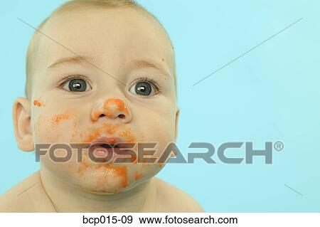 A baby with his face smeared with baby food. View Large Photo Image Stock Photo - A baby with his face smeared with baby food.. Fotosearch