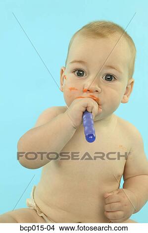 Baby boy holding a spoon in his mouth. View Large Photo Image Picture - Baby boy holding a spoon in his mouth.. Fotosearch