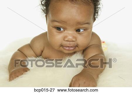 Baby girl crawling on a white fur rug. View Large Photo Image Stock Photo - Baby girl crawling on a white fur rug. . Fotosearch