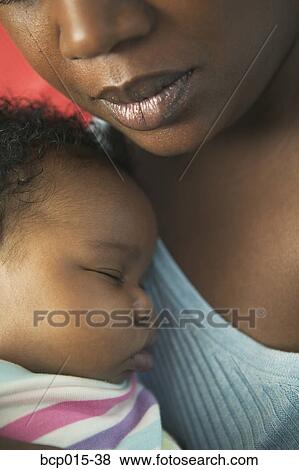 Close-up of a baby being held by her mother. View Large Photo Image Stock Photo - Close-up of a baby being held by her mother. . Fotosearch