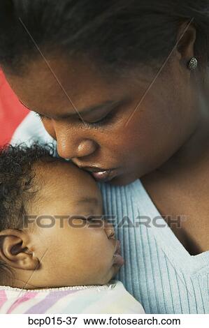 Close-up of a mother holding her baby girl close. View Large Photo Image Stock Photo - Close-up of a mother holding her baby girl close. . Fotosearch