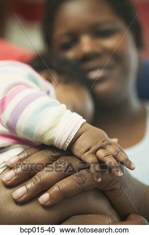 Stock Image - Close-up of mother's and baby's hands. . Fotosearch