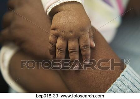 Stock Photo - Close-up of mother's and baby's hands. . Fotosearch