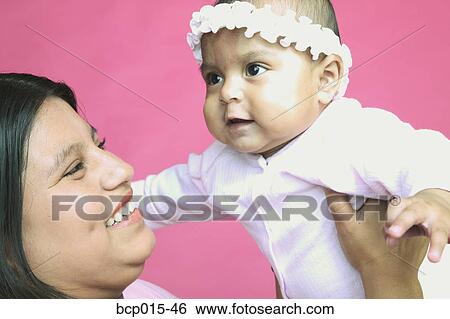 Mother holding up her baby daughter. View Large Photo Image Stock Photograph - Mother holding up her baby daughter.. Fotosearch