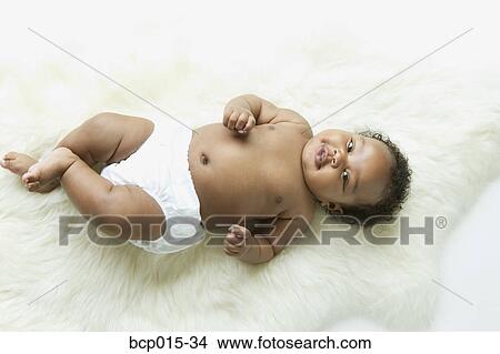 Overhead view of a baby girl on a white fur rug. View Large Photo Image Picture - Overhead view of a baby girl on a white fur rug. . Fotosearch