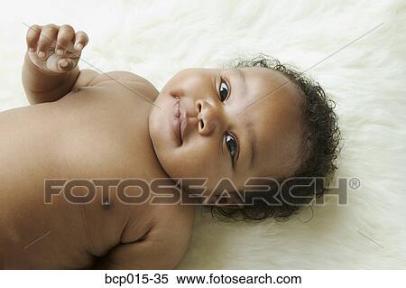 Stock Photography - Overhead view of a baby girl on a white fur rug. . Fotosearch