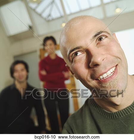 Man with two colleagues in the background. View Large Photo Image Stock Image - Man with two colleagues in the background.. Fotosearch