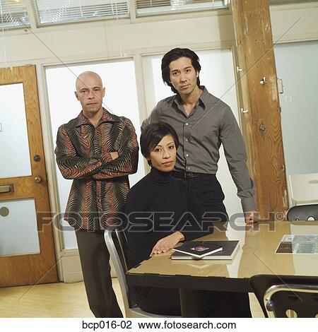 Stock Image - Three business colleagues in a conference room.. Fotosearch