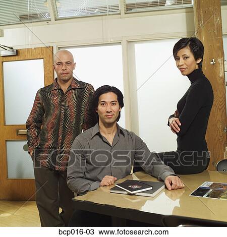 Stock Image - Three business colleagues in a conference room.. Fotosearch