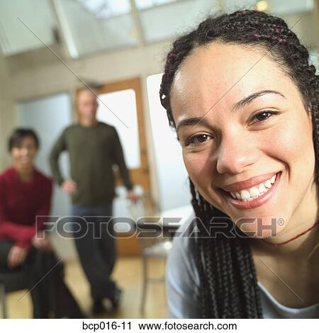 Woman in an office with two colleagues in the background. View Large Photo Image Stock Image - Woman in an office with two colleagues in the background.. Fotosearch