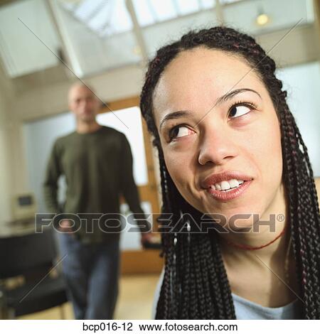 Woman rolling her eyes with a man in the background. View Large Photo Image Stock Image - Woman rolling her eyes with a man in the background.. Fotosearch